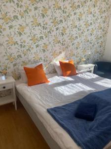 una camera da letto con un letto con cuscini arancioni sopra di Pensionat bryggan a Smögen