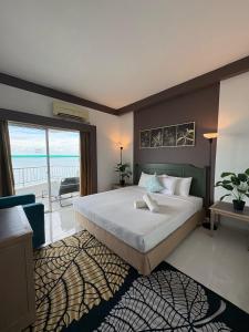 a bedroom with a large bed and a balcony at Seaview Deluxe Rainbow Paradise Tg Bungah 8pax in Tanjung Bungah