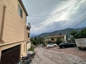 a motorcycle parked next to a building and two cars at Sapphire Lodges in Muzaffarabad