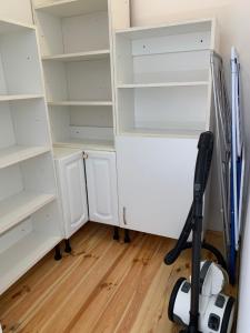 a room with white shelves and a vacuum at Panda apartman in Esztergom