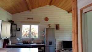 a kitchen with a refrigerator and a window at Maison chalet Soustons in Soustons