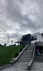 a building with stairs in front of a field at Lux room & ljubljana in Ljubljana