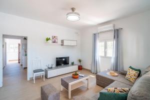 ein Wohnzimmer mit Sofa und Fernseher in der Unterkunft Casa Rural Olivera in La Puebla de Cazalla
