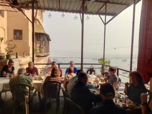 a group of people sitting at tables in a restaurant at Sunrise Lodge in Varanasi