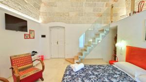 a room with a bed and a staircase and a chair at MandorleOlio in Polignano a Mare