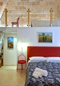 a bedroom with a bed with a red headboard and a red chair at MandorleOlio in Polignano a Mare