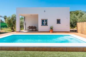 eine Villa mit einem Swimmingpool vor einem Haus in der Unterkunft Casa Rural Olivera in La Puebla de Cazalla