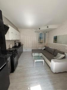 a living room with a couch and a kitchen at Apartament Konopnickiej in Dziwnów