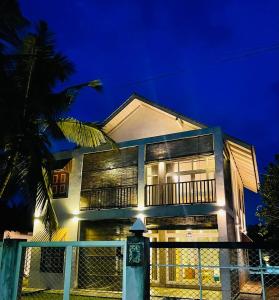 a house with a fence in front of it at night at Aanya Villa by the Beach in Mirissa