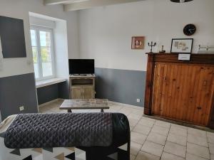 a bedroom with a bed and a table in it at Les Hortensias in La Poultière