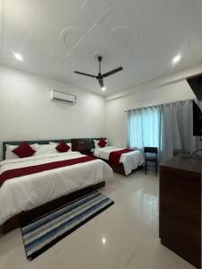 a bedroom with two beds and a ceiling fan at Shree shyam pay at hotel in Khātu