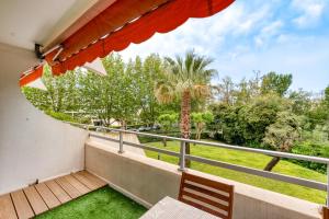 a balcony with a view of a palm tree at Sunshine in La Grande-Motte