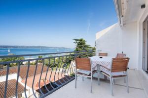 a balcony with two chairs and a table and the ocean at Apartment Rajna in Biograd na Moru
