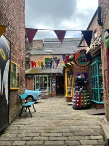an alley with a building with flags and a bench at Apartment in heart of Matlock in Matlock