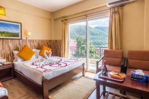a hotel room with a bed and a large window at Pokhara Crown Plaza in Pokhara
