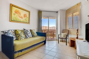 een woonkamer met een bank en een balkon bij Santa Amalia 51 by IVI Real Estate in Torremolinos
