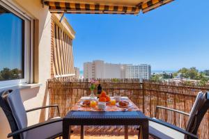 een tafel op een balkon met eten erop bij Santa Amalia 51 by IVI Real Estate in Torremolinos