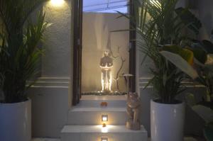 a statue in a mirror in a room with plants at Gilded Palms Villa, Ubud Payangan, Bali in Penginyahan