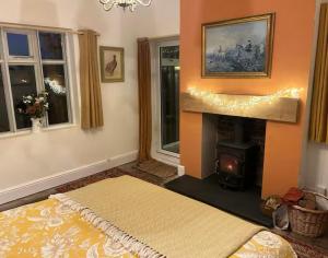 a living room with a fireplace and a bed and windows at Oaklands Farm in Bishops Castle
