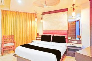a bedroom with a large bed with a red headboard at Collection O Chidambaram Stadium Formerly Hotel Admire Suit in Chennai