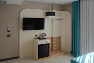 una stanza con una TV su una parete con un tavolino di CONCEPT PERA Hotel a Istanbul