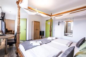 una camera da letto con due letti, un tavolo e una scrivania di Hotel Bannewitz B&B a Bannewitz