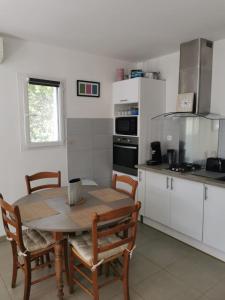 Una cocina con una mesa y sillas en una cocina. en U Casetta, en Patrimonio