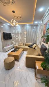 a living room with a large couch and a tv at ParkView City Lake Facing in Malot