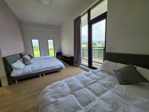 a bedroom with two beds and a large window at Six Children in Gongguan