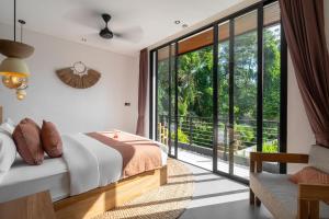 a bedroom with a bed and a large window at Villa Baliga Ubud by BaliSuperHost in Ubud