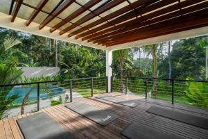 an outdoor deck with yoga mats and a pool at Villa Baliga Ubud by BaliSuperHost in Ubud