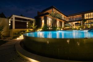 a swimming pool in front of a house at night at Villa Baliga Ubud by BaliSuperHost in Ubud