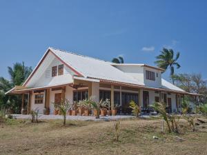 a house with a white roof and palm trees at Beach Front Villa, Saphli beach, Chumphon,Thailand in Ban Tha Samet (1)