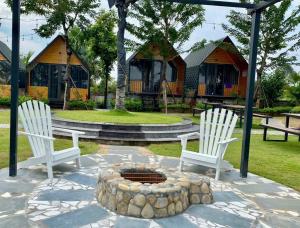 Trai SonにあるYellow Homestayの白い椅子2脚と庭の火炉