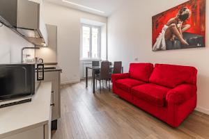 Una sala de estar con un sofá rojo y una mesa. en Vatican Suites Apartment - Vatican City, en Roma