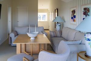 a living room with a couch and a table at Borre Knob Fjordhotel in Juelsminde