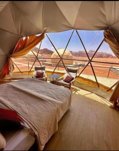 1 dormitorio con cama y vistas al desierto en Night Magic Camp, en Wadi Rum