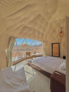 a bedroom with two beds and a view of the desert at Night Magic Camp in Wadi Rum