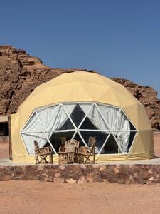 Una tienda de campaña con sillas en medio del desierto en Night Magic Camp, en Wadi Rum