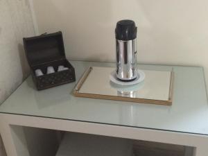 a coffee maker on a glass table with a box at Hotel Paraiso in São Paulo