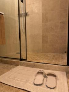 a pair of sandals sitting on a rug in front of a shower at Le Mazet du Moulin in Mouriès +12 photos