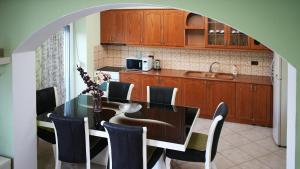a kitchen with a dining room table with chairs at Paris's Apartment in Gjirokastër +13 photos
