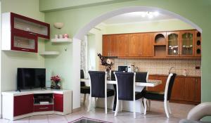 a kitchen with a table with chairs and a television at Paris's Apartment in Gjirokastër