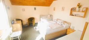 a bedroom with a bed with a crib in it at Pension Bílý Hořec in Vrchlabí