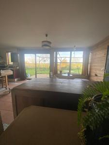 a living room with a large room with windows at Ferme écologique in Saint-Junien-les-Combes