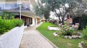 a house with a garden with flowers and a walkway at Apartament Mar Beach Lloret II Aqua in Lloret de Mar