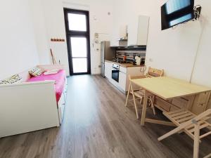 a small room with a table and a kitchen at La casa di Simo in Lodi