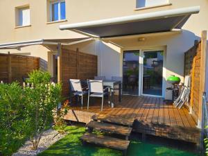 a wooden deck with a table and chairs on it at La Dune 54 - Villa 3P6 in Valras-Plage