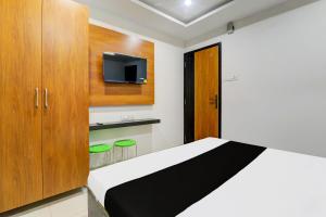 ゴーラクプルにあるSuper Hotel O Aayaanshのベッドとテレビのある小さな寝室