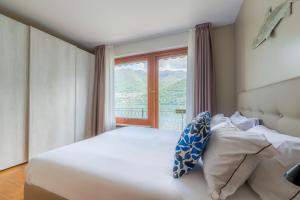BriennoにあるVilla Glicine, by R Collection apartmentのベッドと大きな窓のある寝室